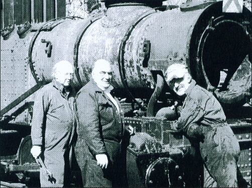 Photo showing Chief
	  Mechanical Engineer, Alan Blackburn (right) with some of the restoration team outside
	  Alston engine shed, in April 2003.